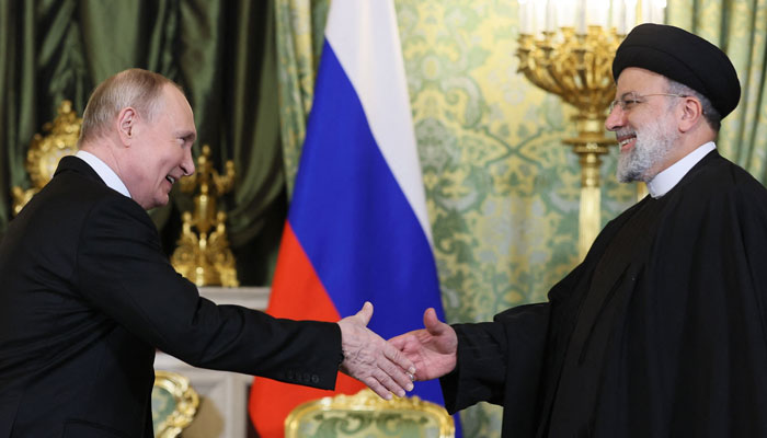 Russia´s President Vladimir Putin (L) shakes hands with Irans President Ebrahim Raisi during their meeting in the Kremlin in Moscow on December 7, 2023. — AFP