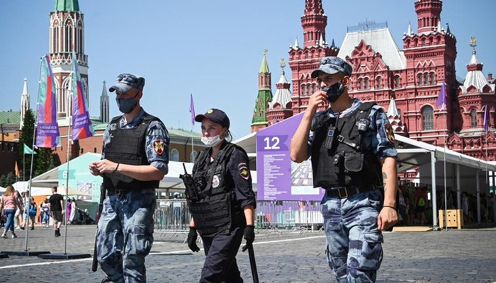 Russian police and National Guard (Rosgvardia) servicemen wearing face masks walk along Red Square in central Moscow. — AFP/File