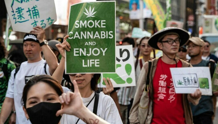 People take placards in a march to call for the legalization of cannabis (marijuana) in the streets of Shibuya in Tokyo on May 4, 2023. — AFP