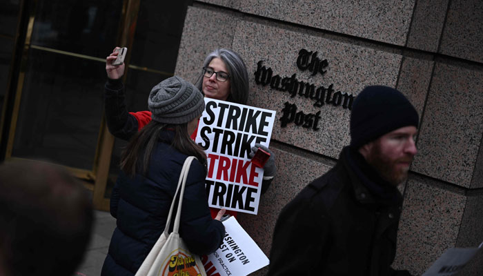Employees of the Washington Post joined by supporters, walk the picket line during a 24-hour strike, outside of Washington Post headquarters in Washington, DC, on December 7, 2023. — AFP