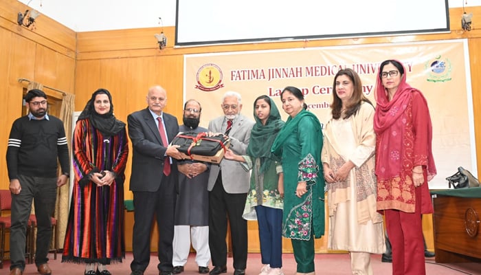 Caretaker Provincial Health Minister Prof Dr Javed Akram distributes a laptop to a student in Fatima Jinnah Medical University on December 7, 2023. — Facebook/Fatima Jinnah Medical University