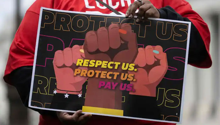 A woman holds a placard during a protest for an increase in wages. — AFP/File