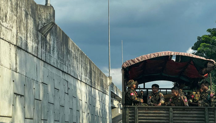 This photo taken on Dec 4, 2023 shows member of Myanmars military patrolling on a truck down a street in Yangon. -AFP