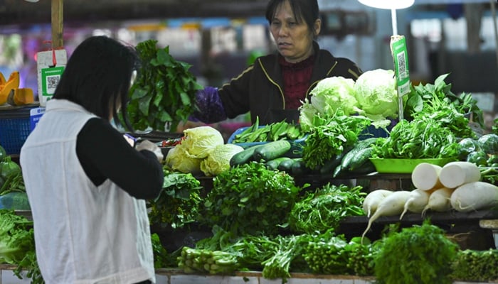 This photo shows a resident buying vegetables at a market in Nanning, in Chinas southern Guangxi region. — AFP/File