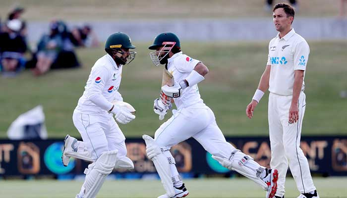 Pakistani players run between the wickets as New Zealand Trent Boult looks on during the first Test match between and Pakistan at the Bay Oval in Mount Maunganui. — AFP/File