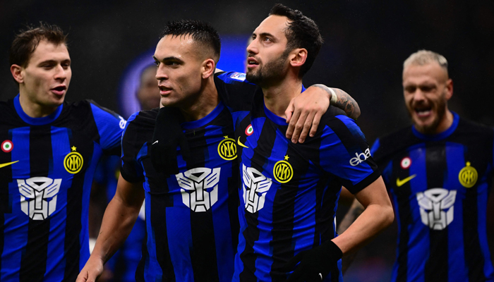 Inter Milans Hakan Calhanoglu (R) celebrates after scoring a goal during the Italian Serie A football match Inter Milan vs Udinese on December 9, 2023 in Milan. — AFP