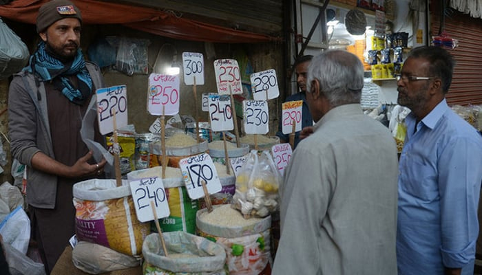 People buy rice at a wholesale market in Karachi on February 1, 2023. — AFP