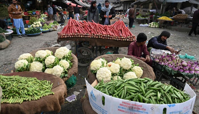 Vendors wait for customers at a vegetable market in Islamabad on February 3, 2023. — AFP