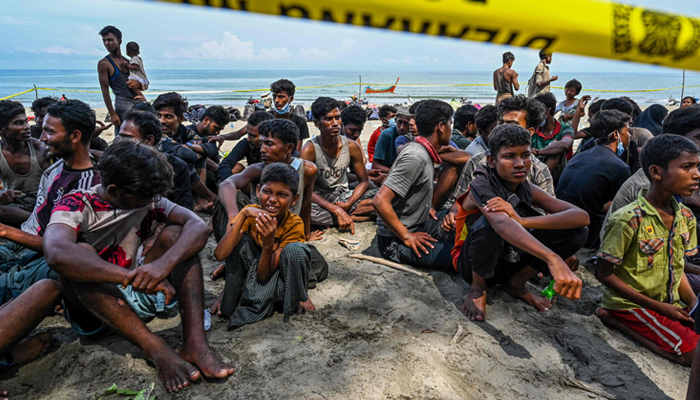 Newly-arrived Rohingya refugees gather and rest at a beach in Laweueng, Pidie district in Indonesias Aceh province on December 10, 2023. — AFP