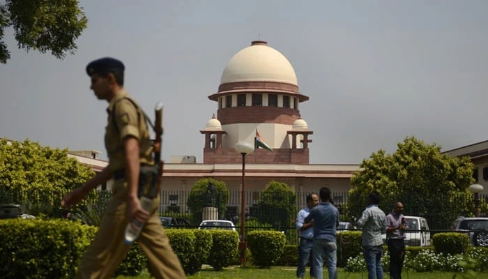 The Supreme Court of India is seen in this picture as a security official passes by with media standing at the front. — AFP/File