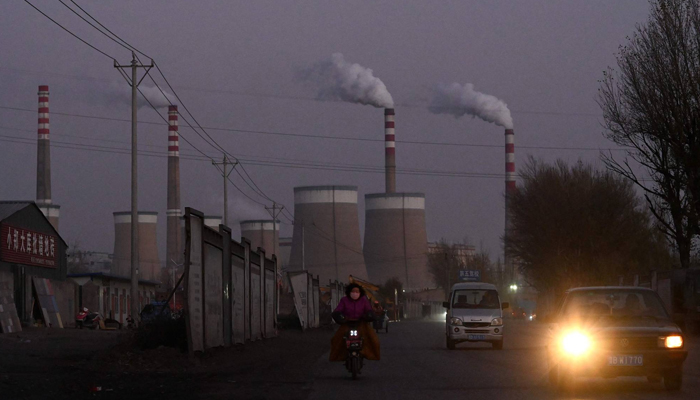 Commuters pass a coal-fired power station in Datong, in Chinas northern Shanxi province. — AFP/File