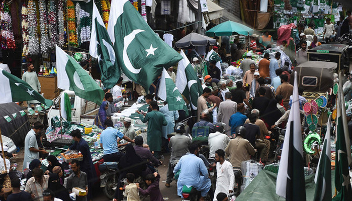 People throng a market where vendors sell Pakistans national flags in Karachi ahead of Independence Day. — AFP/File