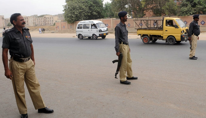 This image shows Sindh Police personnel standing on a road. — AFP/File