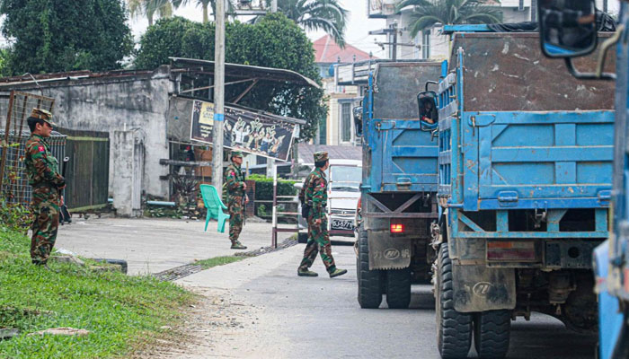 Fighters of the ethnic rebel group Taang National Liberation Army standing guard in the town of Namhkam in northern Shan state.  . — AFP File