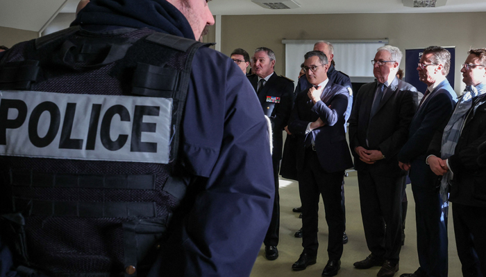 French Interior Minister Gerald Darmanin (C) attends a meeting with police officers at the Calais police station, northern France, on December 15, 2023. — AFP