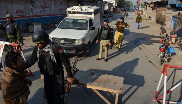 This image shows Peshawar police checking civilians on a check point. — AFP/File