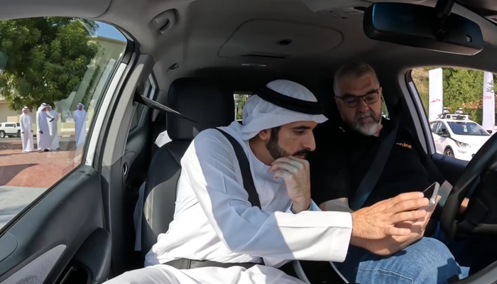 Sheikh Hamdan bin Mohammed bin Rashid Al Maktoum, Crown Prince of Dubai and Chairman of The Executive Council of Dubai checks the drivers phone during the first demo ride of the Chevrolet Bolt-based Cruise autonomous vehicle in Jumeirah 1 area in this still on December 15, 2023. — X/@rta_dubai