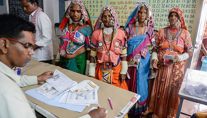 An official checks the names of Indian lambadi tribeswomen at a polling station during Indias general election at Pedda Shapur village. ─ AFP/File