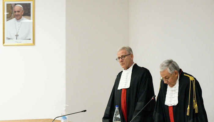The Vatican Media shows President Giuseppe Pignatone (R) and Professor Venerando Marano (L), Director of the Department of Law at the University of Rome Tor Vergata, during the verdict of the trial for alleged financial wrongdoing of Senior Cardinal Angelo Becciu and nine others in The Vatican on December 16, 2023. — AFP