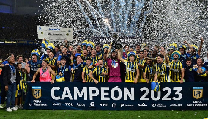 In this photo released by Telam, Rosario Central footballers celebrate with the trophy in Santiago del Estero, Argentina on December 16, 2023. — AFP