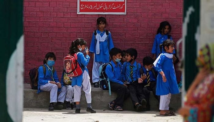 School children are sitting outside a school. — AFP/File