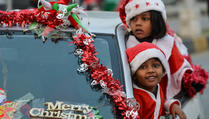 Children wearing Santa Claus outfits take part in a Christmas peace rally in Karachi on December 17, 2023. — AFP