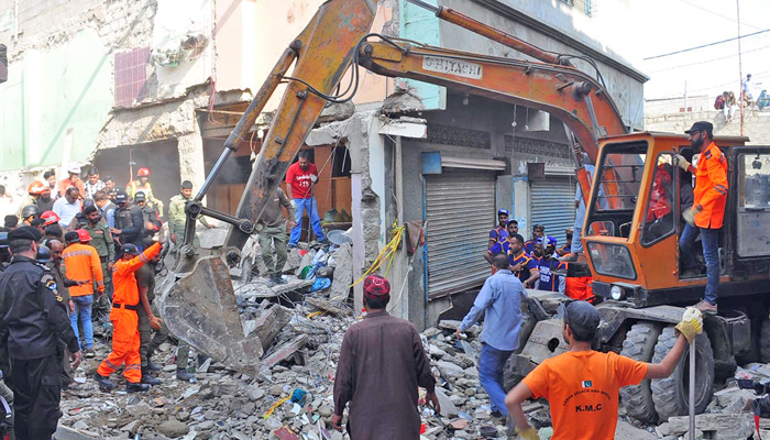 Volunteers and Security personnel are busy assisting in the cemented debris of buildings after the gas cylinder blast at Machar Colony in Karachi on December 18, 2023. — Online
