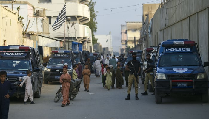 Police personnel stand guard during a search operation on the outskirts of Karachi on November 17, 2023. — AFP