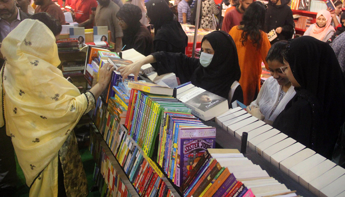 People are busy buying books on book stalls during the 18th Book Mela at the Expo Center in Karachi on December 17, 2023. Online