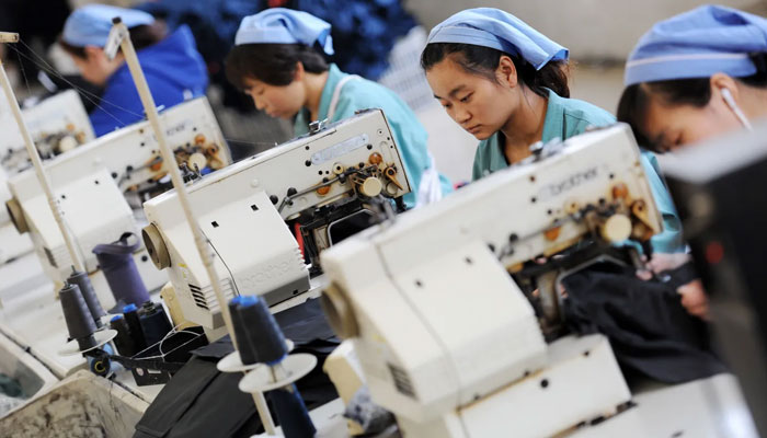 This photo taken on May 19, 2015 shows workers producing clothes in a factory in Huaibei, east Chinas Anhui province.  — AFP