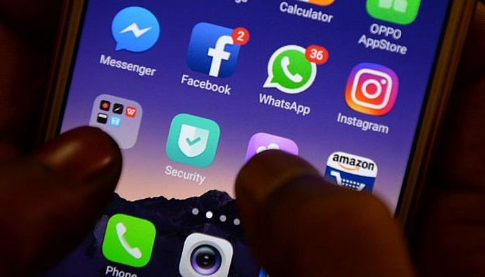 A man uses a smartphone Facebook, Instagram, and WhatsApp, can be seen on the screen. —  AFP/File