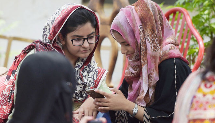 This image shows students using their mobile phones in Islamabad. — AFP/File