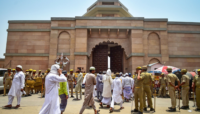 Policemen stand guard as Muslim devotees arrive to offer Friday noon prayer at the Gyanvapi mosque in Varanasi on May 20, 2022. — AFP