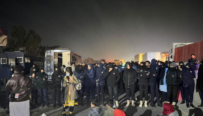 Islamabad police stand guard as Baloch marchers reach Islamabad to protest against the extra-judicial killings in Balochistan province on December 21, 2023. — X/@sairabaluch_)