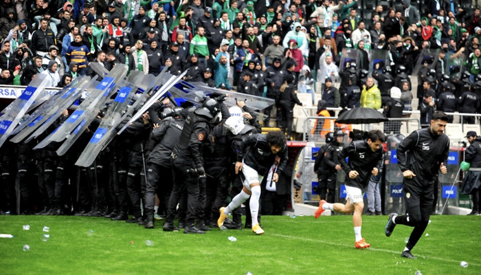 This image shows footballers escaping the crowd as police block the violence in the stadium. — AFP/File