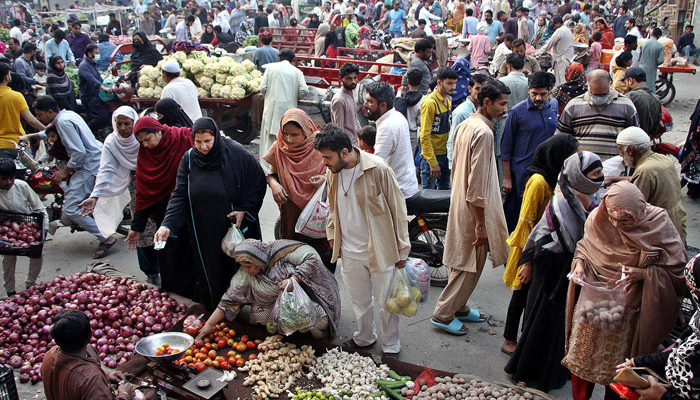 People buy vegetables at Small Vegetable Weekly Market located on Tajpura area in Lahore December 3, 2023. — AFP