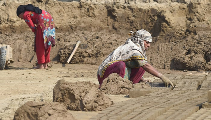 A Pakistani woman worker makes clay bricks at a brick kiln on the outskirts of Lahore. — AFP/File