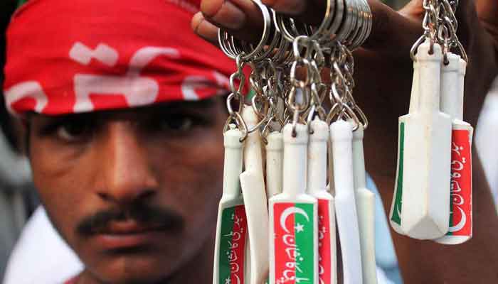 Man selling keychains of PTI party symbol bat in Lahore. —Online/file