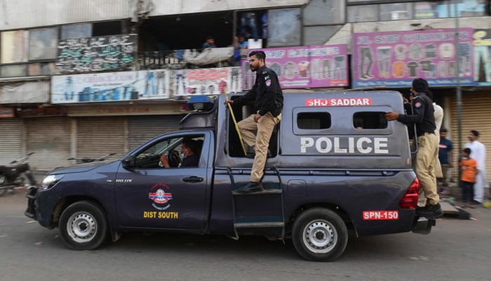Police personnel can be seen on a police vehicle in Karachi. — AFP/File