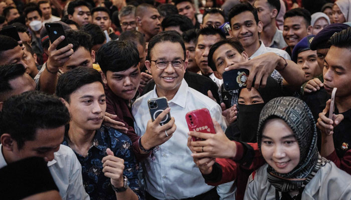 Presidential candidate Anies Baswedan (C) poses for pictures with students after a public dialogue during his campaign rally at Bina Bangsa University in Serang on December 21, 2023. — AFP