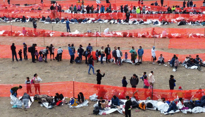 Migrants await processing by immigration authorities after crossing the US-Mexico border in Eagle Pass, Texas, December 20, 2023.  — AFP