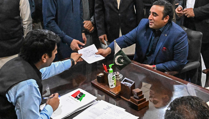 Pakistan Peoples Party chairman Bilawal Bhutto Zardari (R) submits his nomination papers at the deputy commissioner office in Shahdad Kot of Sindh province on December 24, 2023. — AFP