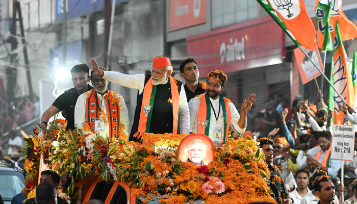Indias PM Narendra Modi (C) waves to supporters during a road show as a part of Bharatiya Janata Partys election campaign ahead of the Telangana state assembly elections, in Hyderabad on November 27, 2023. — AFP