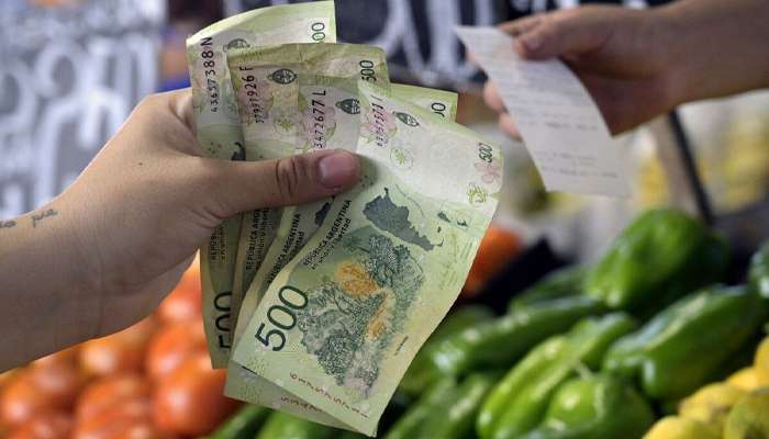 A woman pays for fruits and vegetables in Buenos Aires, Argentina.—AFP/File