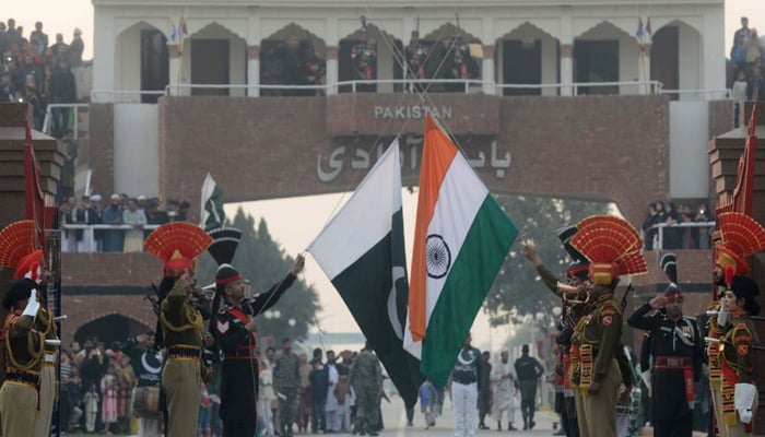 Flags of Pakistan (left) and India are held by the border forces of the countries at the international border of Pakistan-India. — AFP/File