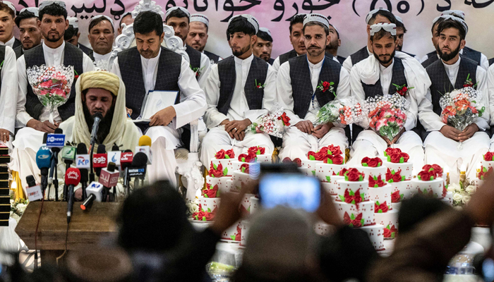 Afghan grooms look on during a mass ceremony at a Kabul wedding hall on December 25, 2023. — AFP