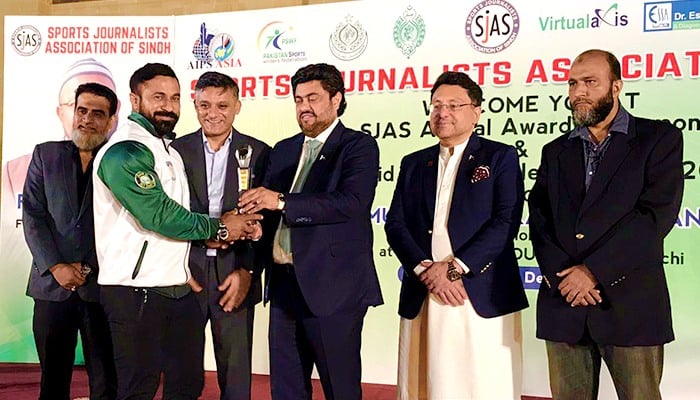 Sindh Governor Muhammad Kamran Khan Tessori awards a player during the 6th Annual Sports Award and Rashid Siddiqui Talent Award ceremony on December 26, 2023. — Facebook/PBBF - Pakistan Body Building Federation