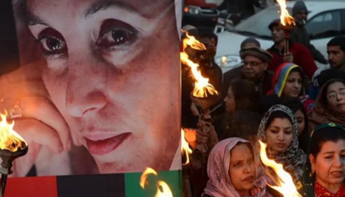 Supporters of Benazir Bhutto gather on the death anniversary of Bhutto at a rally in Lahore on December 27, 2013.—AFP
