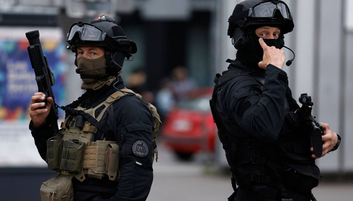 Officers from the RAID tactical unit of the French National Police patrol a street in Lille. — AFP