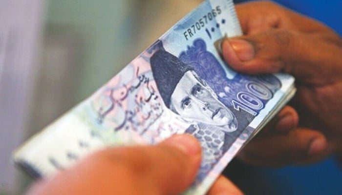 In this image a person holding a Pakistan currency note.—AFP/File
